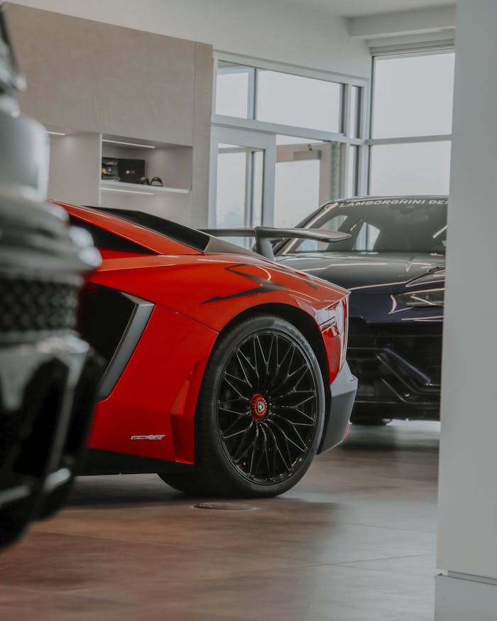 about-02 Sleek red and black Lamborghinis showcased in an elegant car showroom.