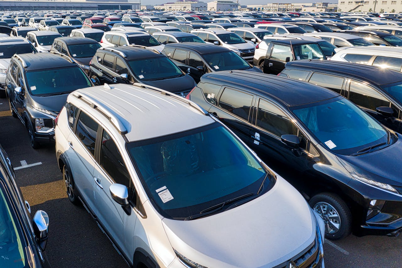 services-img Modern sparkling clean new automobiles on asphalt parking near factory of manufacture in daytime