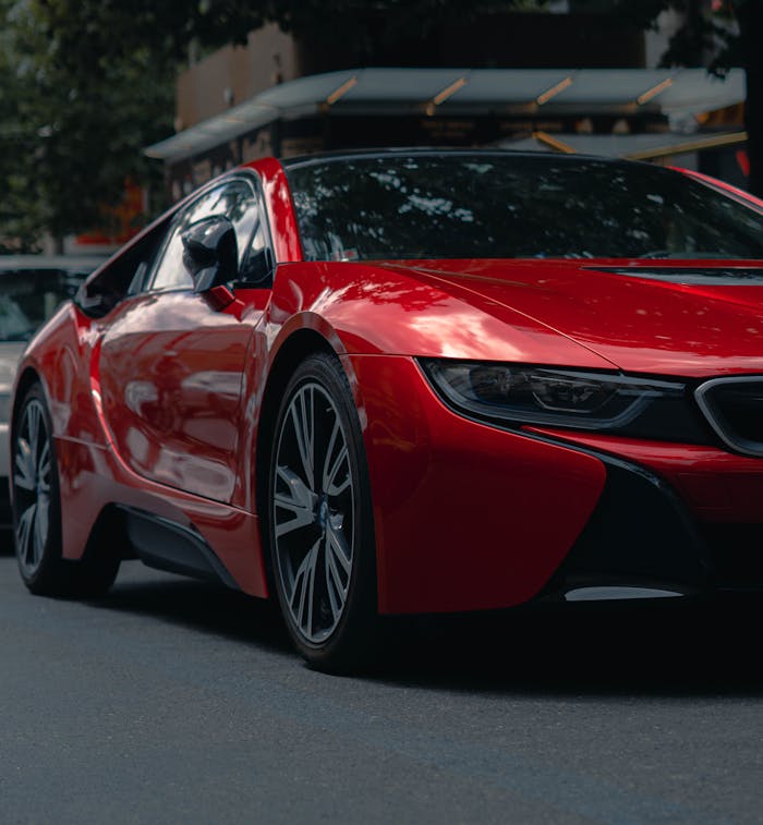 pexels photo 6771170 Dynamic close-up of a modern red sports car parked on an urban street, perfect for automotive enthusiasts.